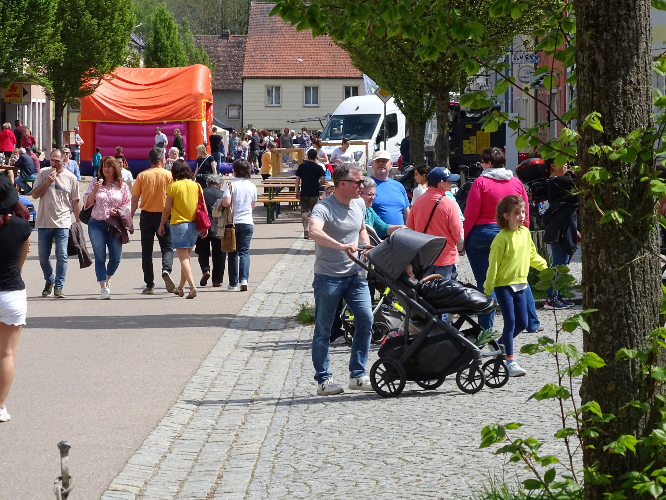 Fruehlingsfest Besucher in der Marktstraße.
Im Hintergrund die viel genutzte Hüpfburg.